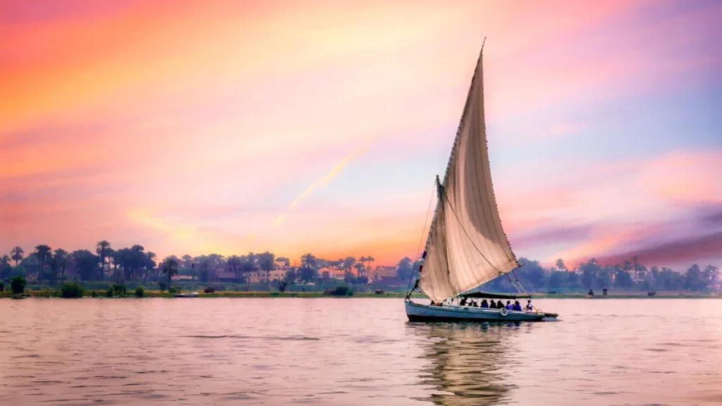 Traditional felucca sailing on the Nile in Aswan at sunset during an Egypt honeymoon itinerary