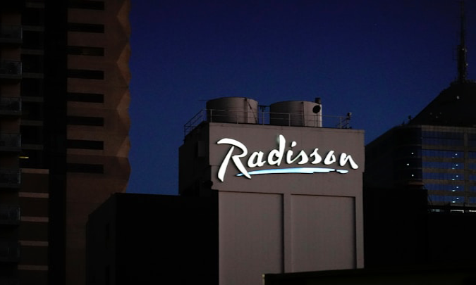 Radisson hotel stay with traveler comparing hotel prices and rewards benefits before booking